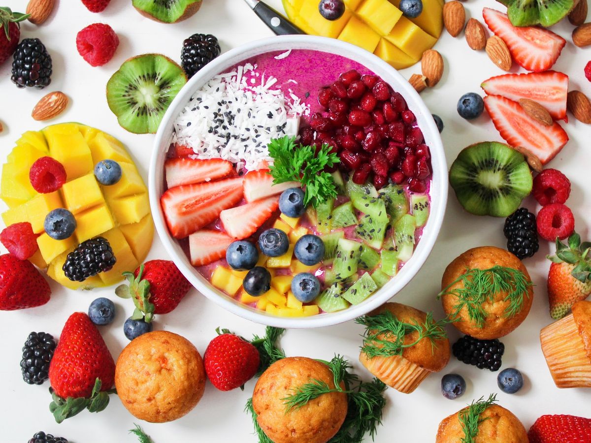 A colorful fruit-topped bowl and breakfast ingredients