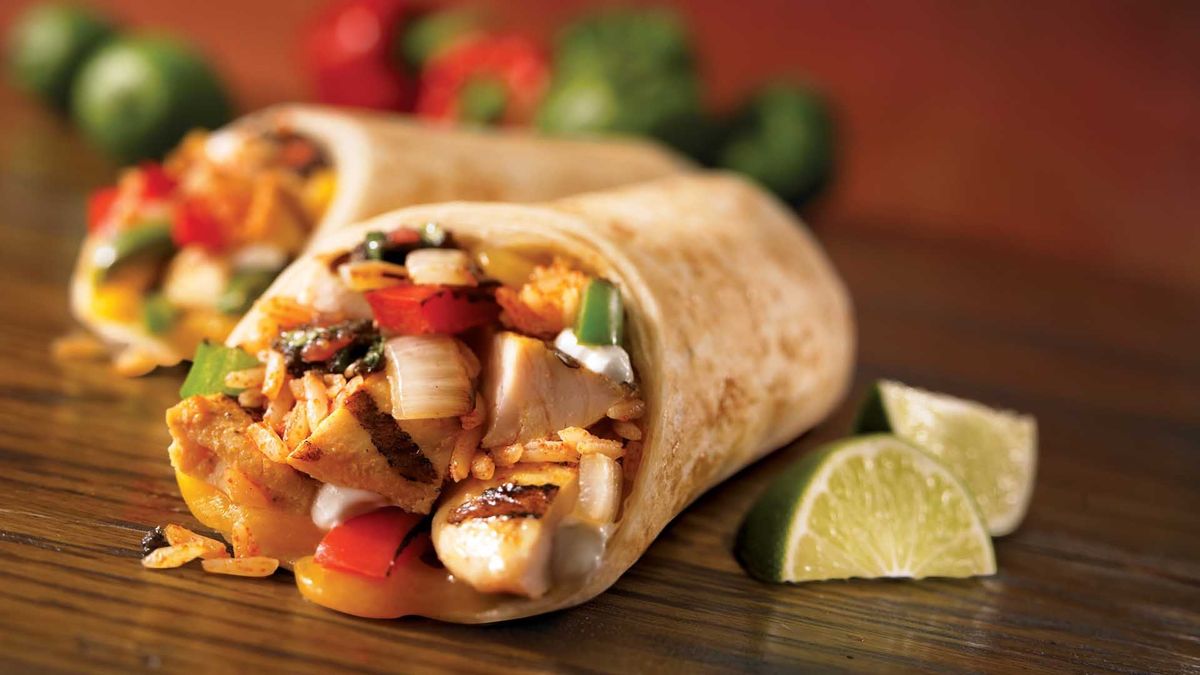 A filled wrap beside fresh vegetables