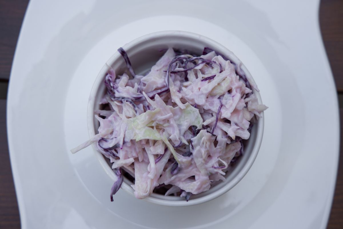 Shredded red cabbage salad in a white bowl